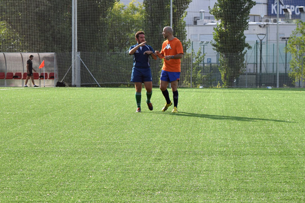 Dos árbitros de rugby hablan en un campo entre dos partidos.